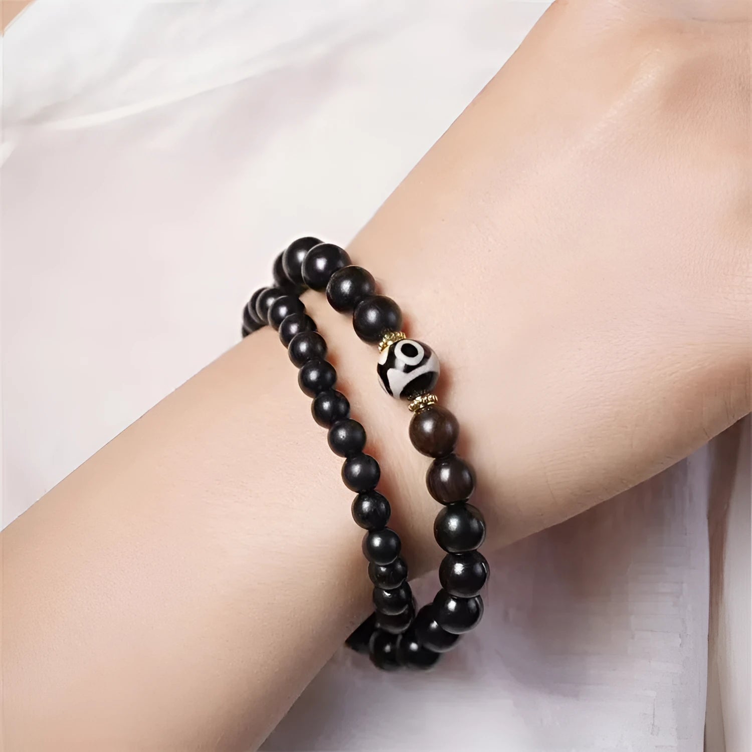 Close-up of Tibetan-style ebony wood bead bracelet showing 8mm diameter beads in two-circle layered design