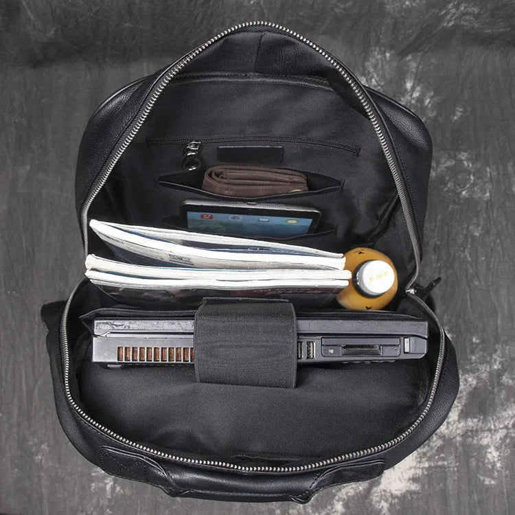 Men's black first layer cowhide leather travel backpack with multiple zipper pockets and top handles, 30cm by 42cm.
