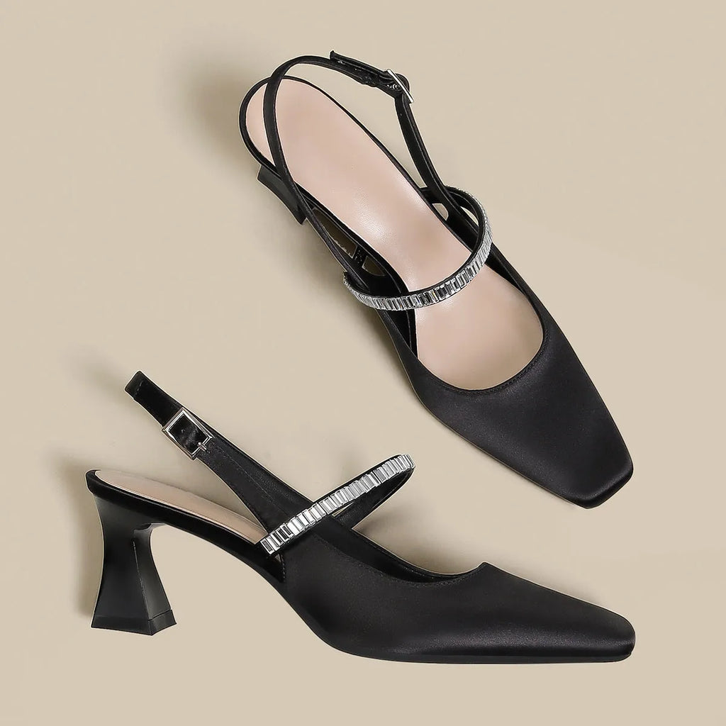 Women's black stiletto heel sandals with a closed toe and a silver buckle strap across the instep.