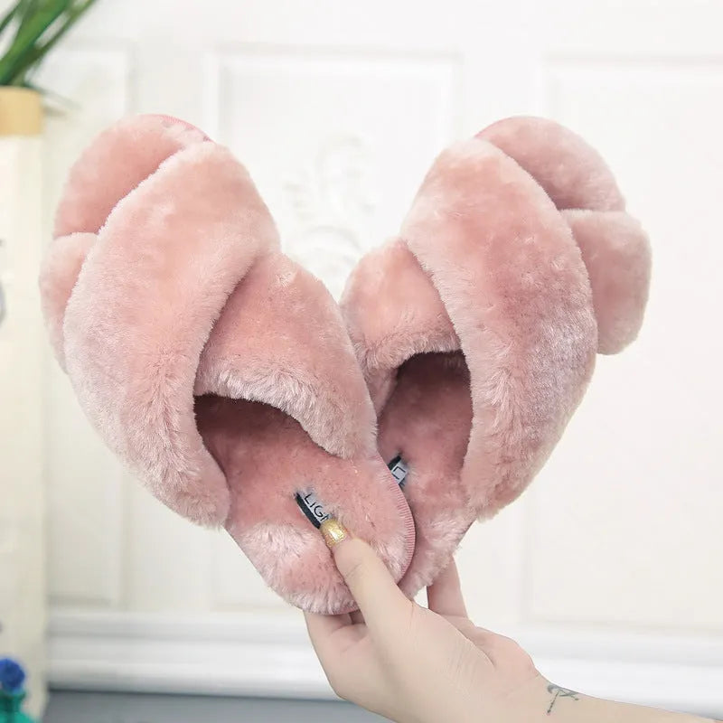 Women's black cross open-toe fur slippers on a white background, showing criss-cross upper and patterned sole.