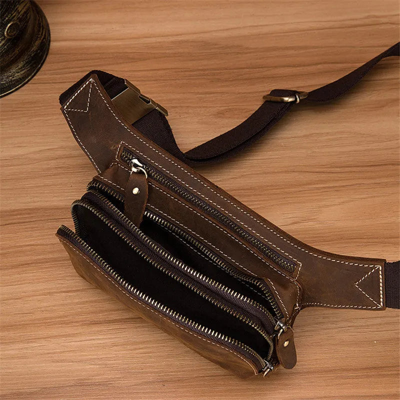 Brown top layer cowhide men's waist bag with pull cord closure, shown with a 10-inch laptop and mobile phone.