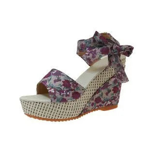 Women's wedge peep toe sandals with an ankle strap buckle in a floral pattern.