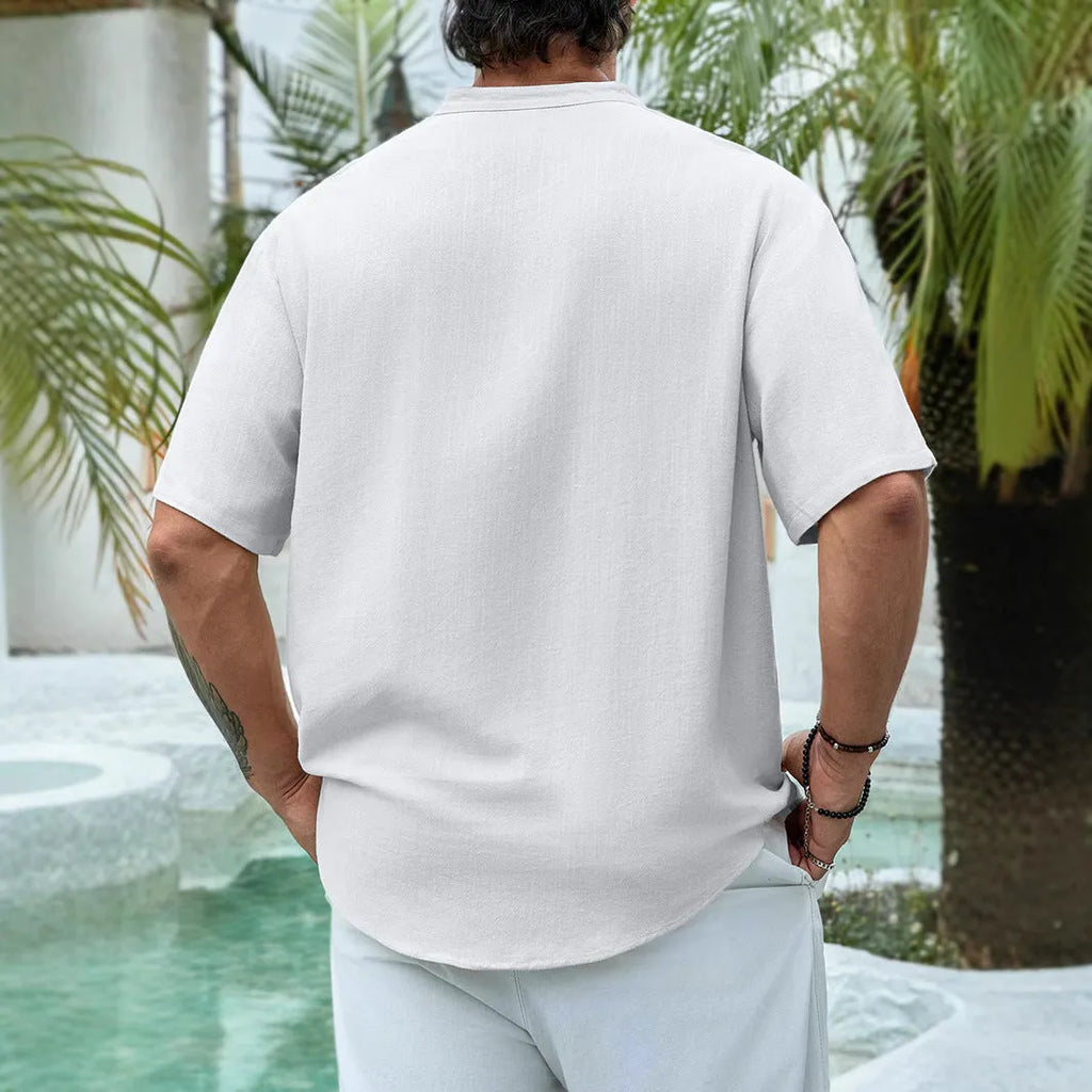 Man wearing a deep V-neck multi-button short sleeve casual shirt in a solid colour.