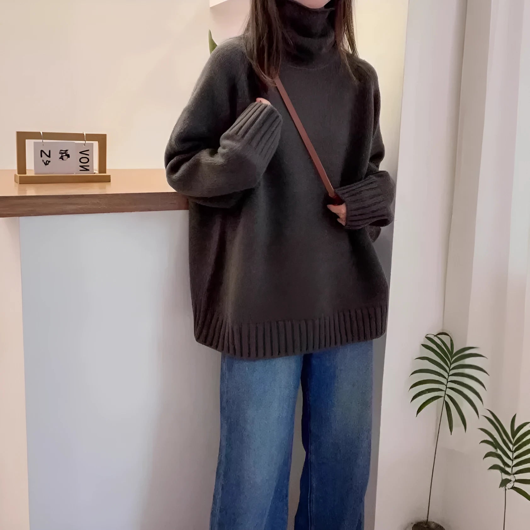 Women's loose fit black turtleneck sweater with a thick curling pile collar.