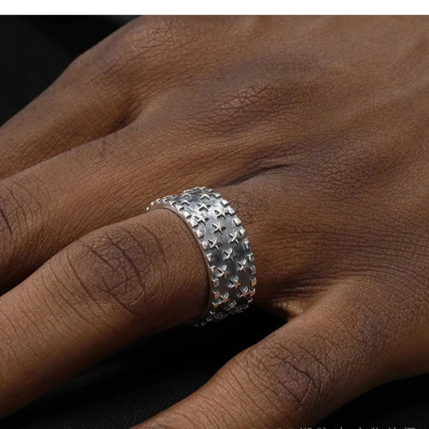 Adjustable sterling silver ring showing multiple five-pointed star geometric pattern on band
