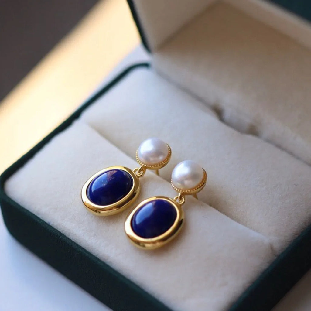 A pair of silver earrings with blue lapis lazuli pearls and auspicious patterns.