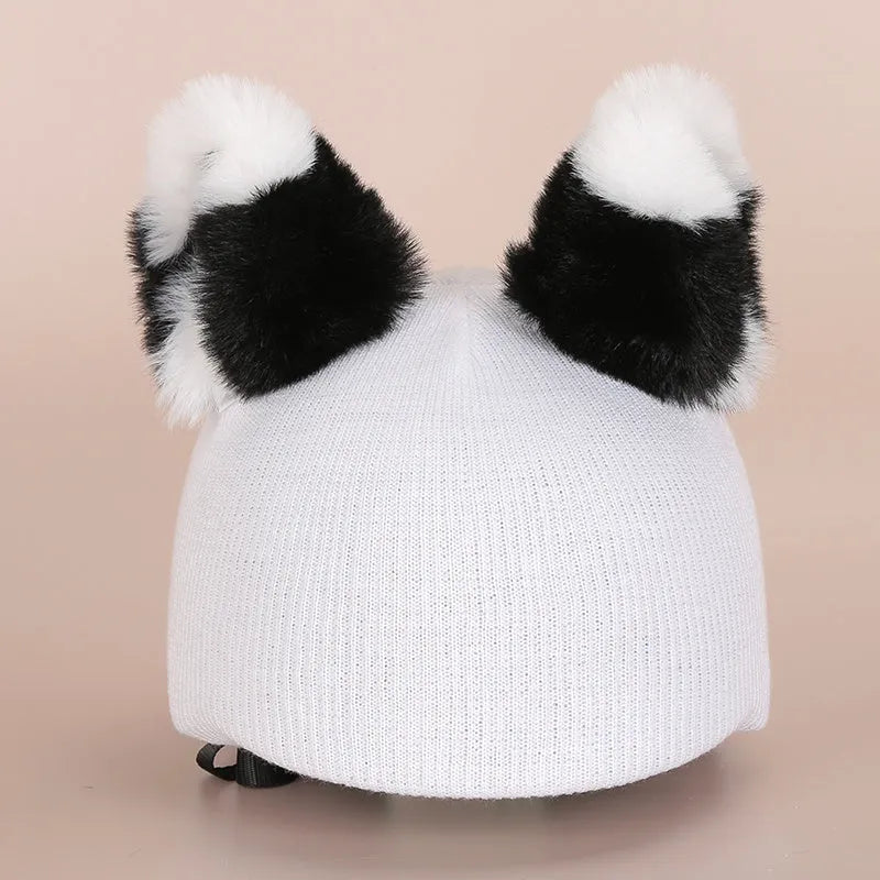Cartoon character plush cap decoration sitting on top of a blue ski helmet.