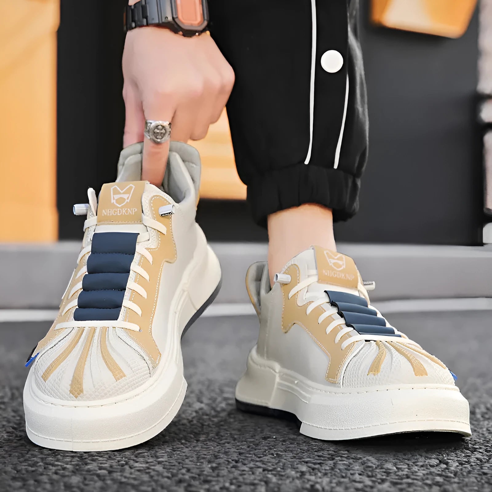 Men's beige and black low-top casual sneakers with an elastic band and round toe.