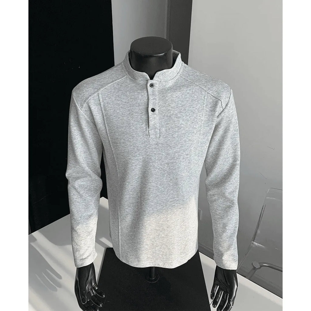 Man wearing a grey patchwork shoulder polo shirt with a stand-up collar and long sleeves.