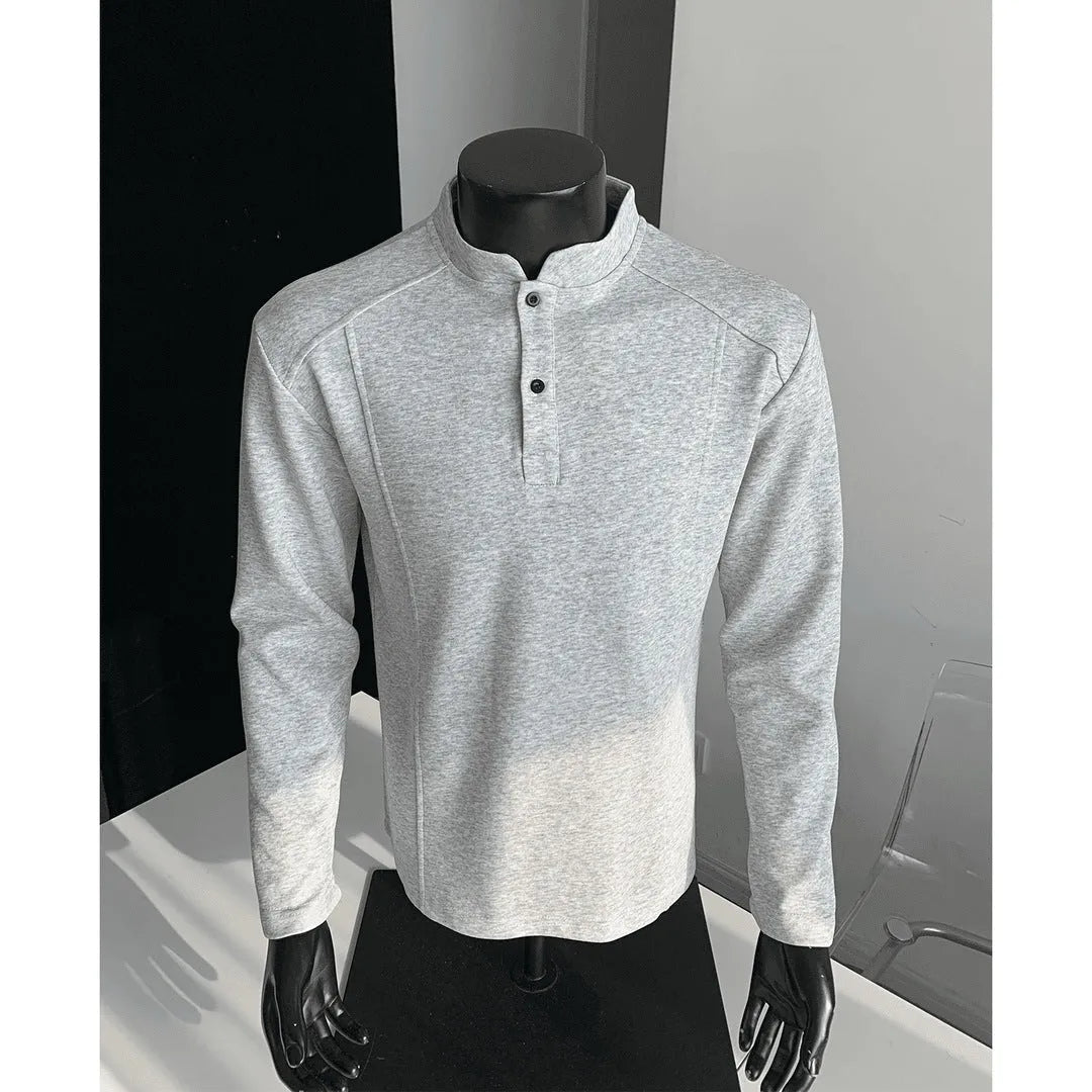 Man wearing a grey patchwork shoulder polo shirt with a stand-up collar and long sleeves.