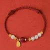 Adjustable silver bracelet with red Hetian jade detail on a wrist.