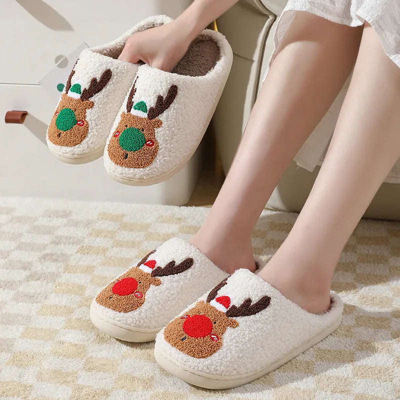 Christmas winter home slippers in red with plush upper and anti-slip sole on a wooden floor