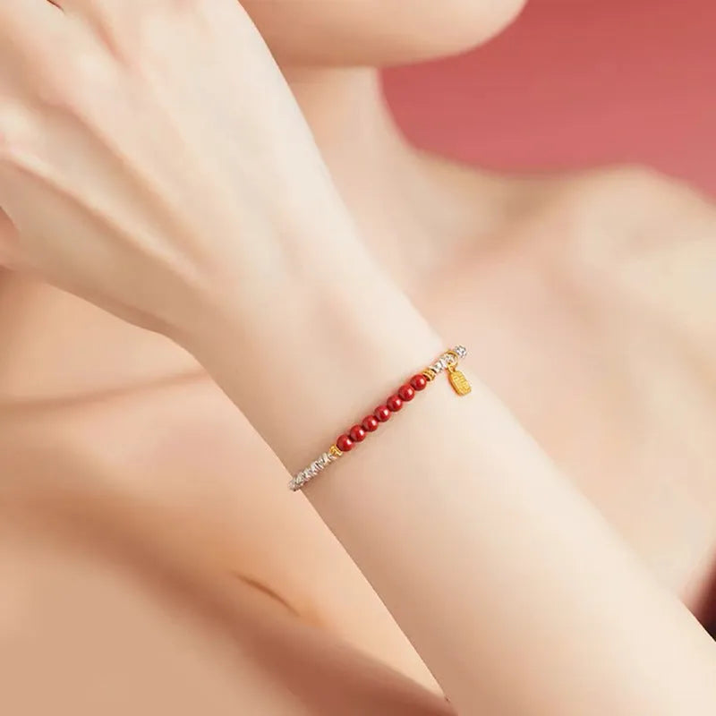 Silver-toned couple bracelet with geometric charm and round beads on white background
