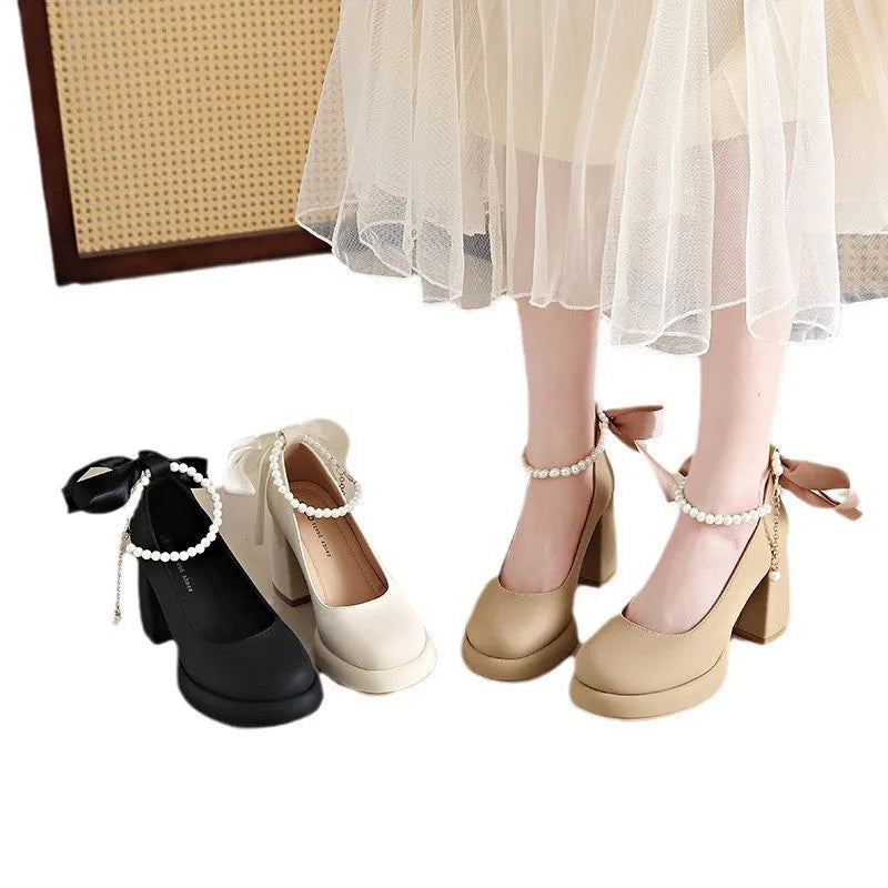 Beige women's Mary Jane shoes with chunky heel, round toe, and pearl- detail ankle strap on a white background.