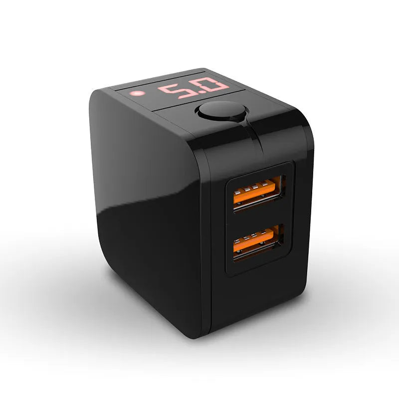 Black dual USB fast charger with digital display showing voltage and current, next to UK plug