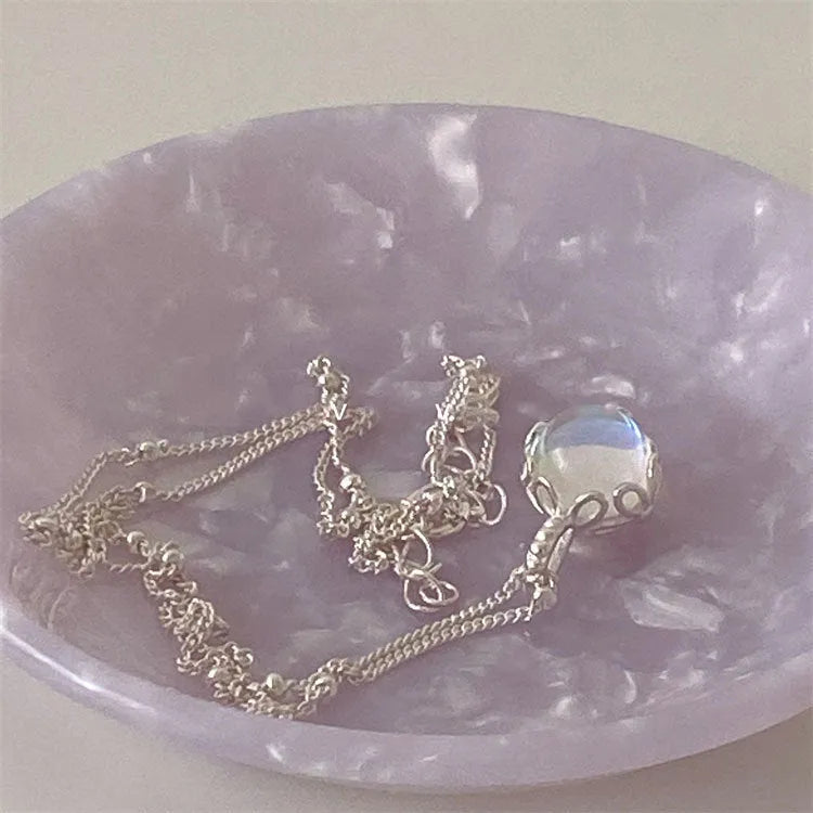 Geometric ornamental stone pendant on a silver curb chain necklace for women.