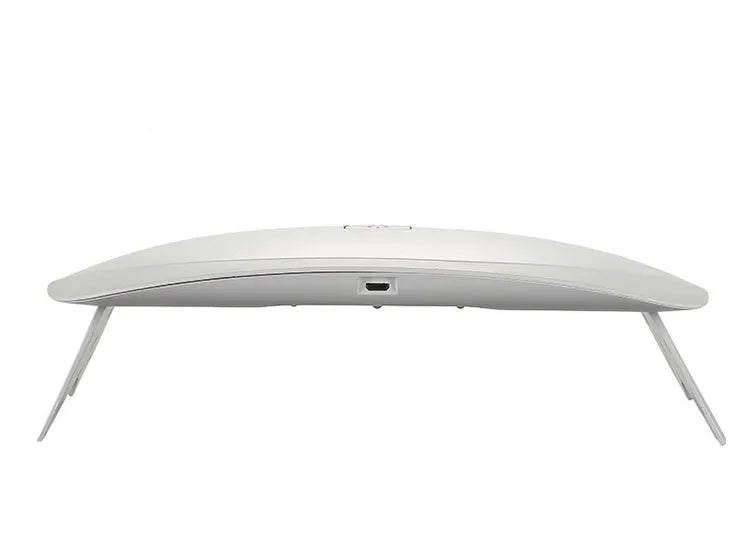 Portable nail dryer in white colour with phototherapy lamp and sealing function on a table