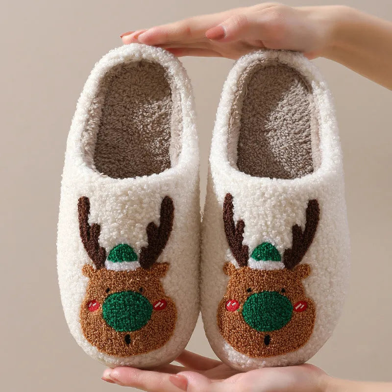 Christmas winter home slippers in red with plush upper and anti-slip sole on a wooden floor