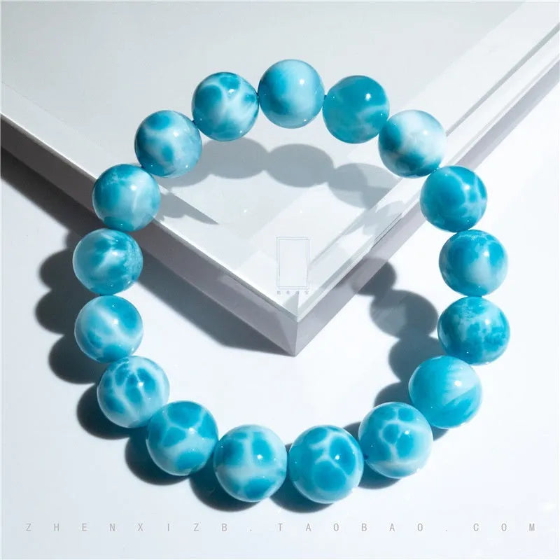 Blue natural crystal sea-pattern stone and Bodhi bracelet with pearl details on a white background.