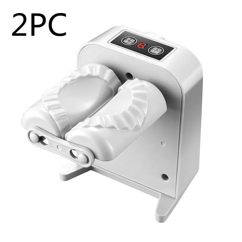 White automatic electric dumpling maker machine with USB cable, brush, and spoon on a kitchen counter.