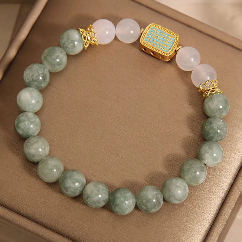 Close-up of a women's oil green emerald crystal bracelet featuring a five-piece sutra design.