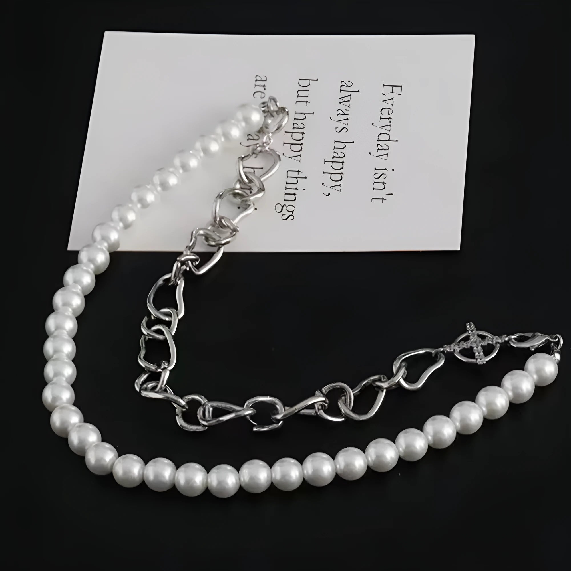 White acrylic geometric asymmetric pendant necklace on a twisted chain, shown at clavicle length.