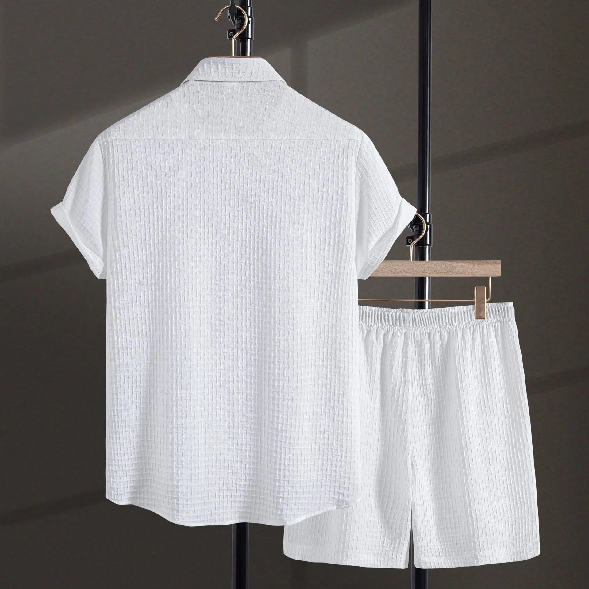 A man wearing a solid colour short-sleeve shirt and matching shorts from a casual beachwear set.