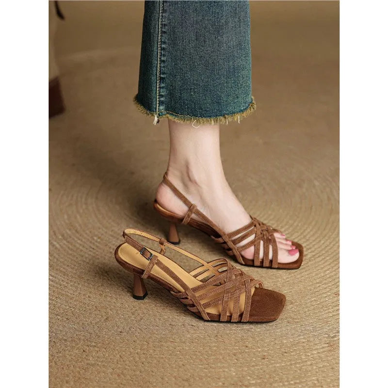 Women's light brown retro sandals with thin cross straps, square toe, and a mid-height block heel on a wooden floor.
