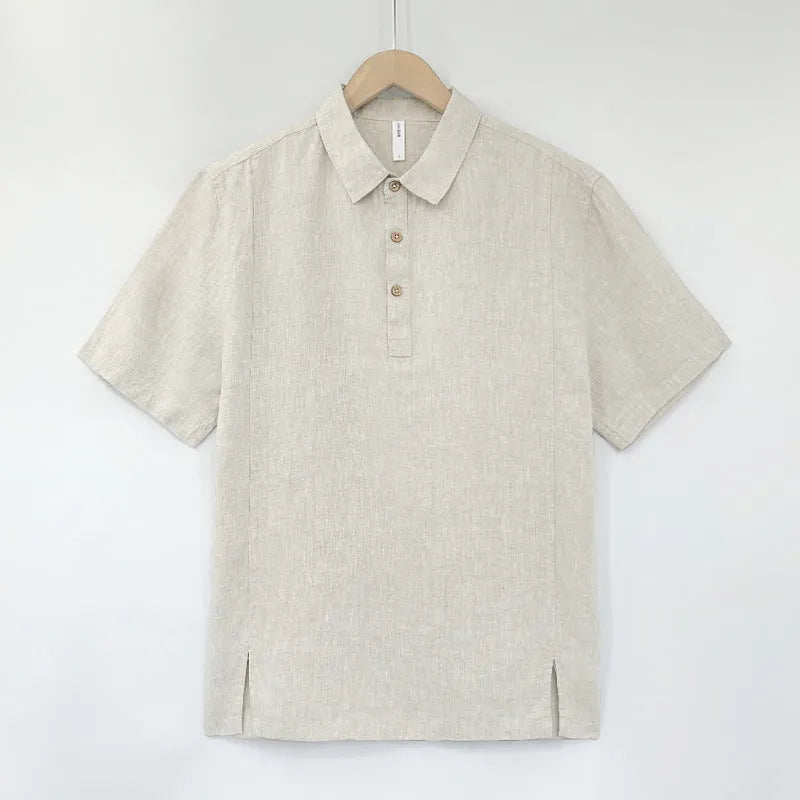 Man wearing a loose-fit grey-green linen short-sleeve top in a summer setting.