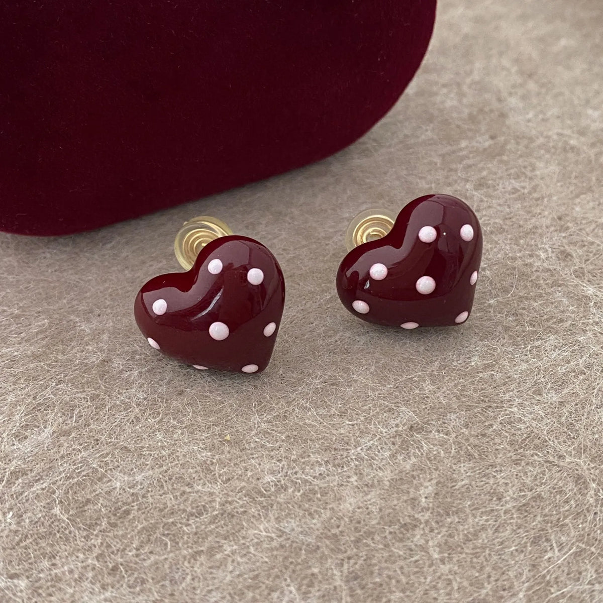 Red drip glaze heart earrings in copper, shown as no-piercing ear clips and stud earrings