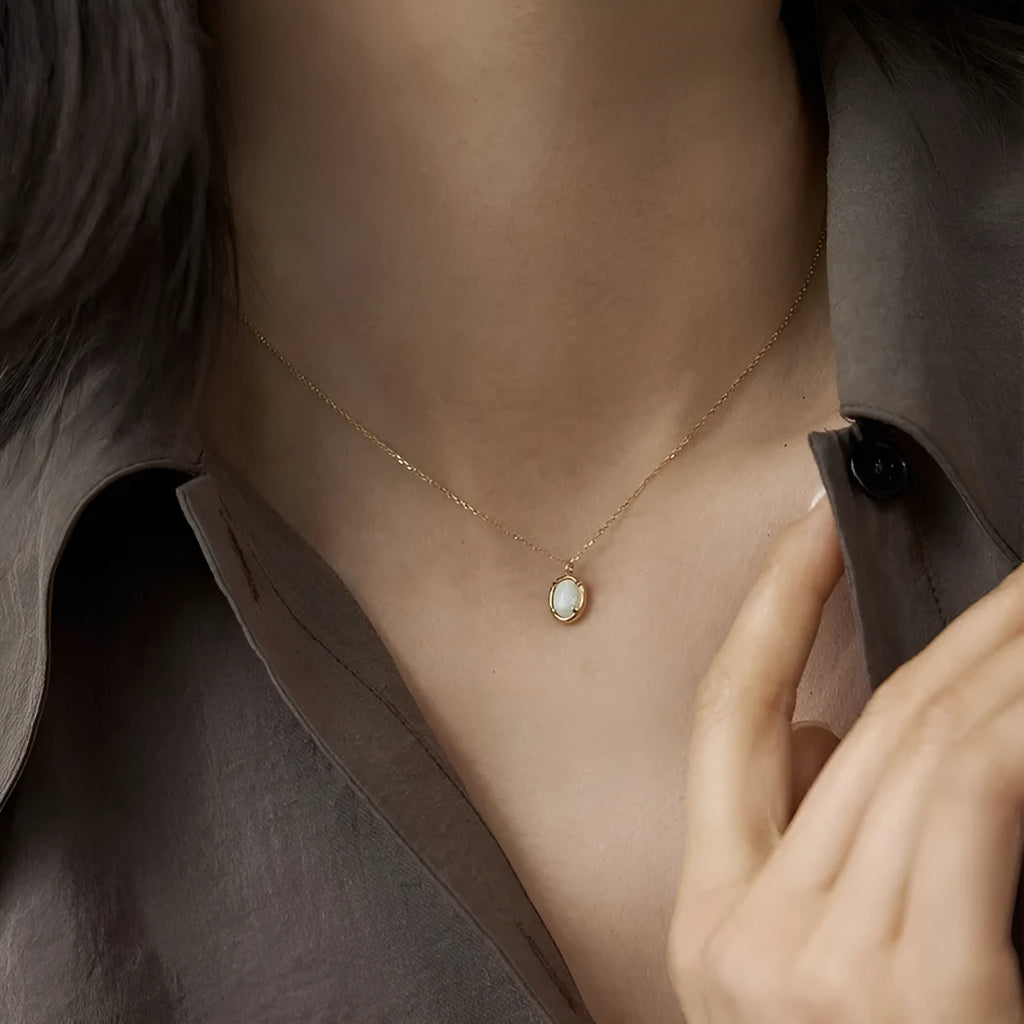 Oval jelly opal geometric pendant on a sterling silver chain with gold plating.