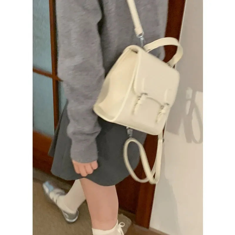 Simple PU college backpack in white, black, wine red, or silver with polyester lining and sewing thread detail