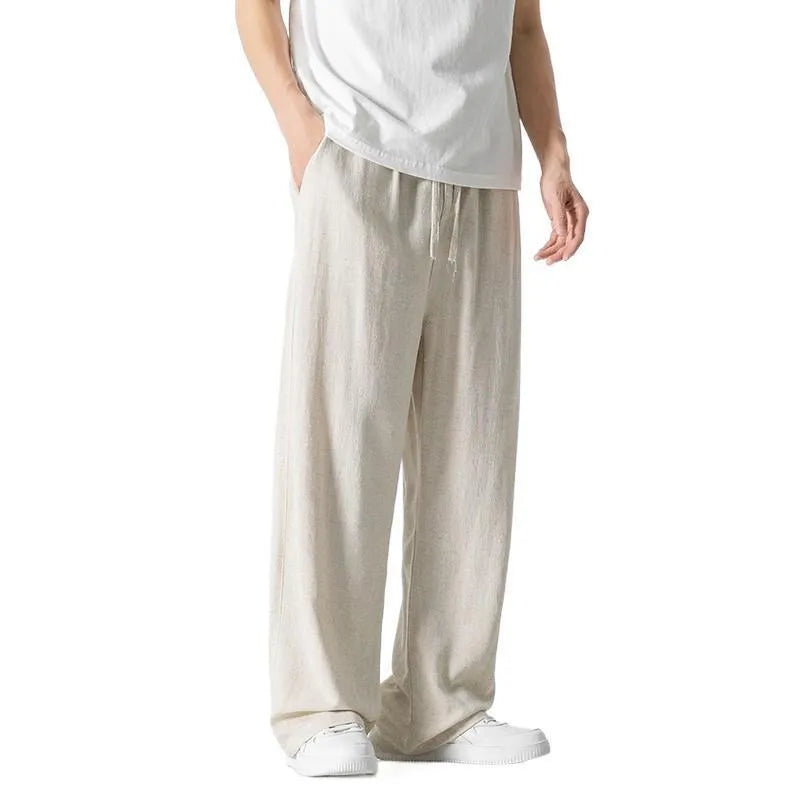 Man wearing beige bamboo fibre cropped trousers with a drawstring waist and straight legs.