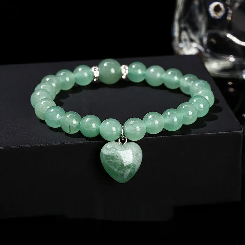 Natural crystal Tigereye love pendant bracelet with heart geometric design on woman's wrist.