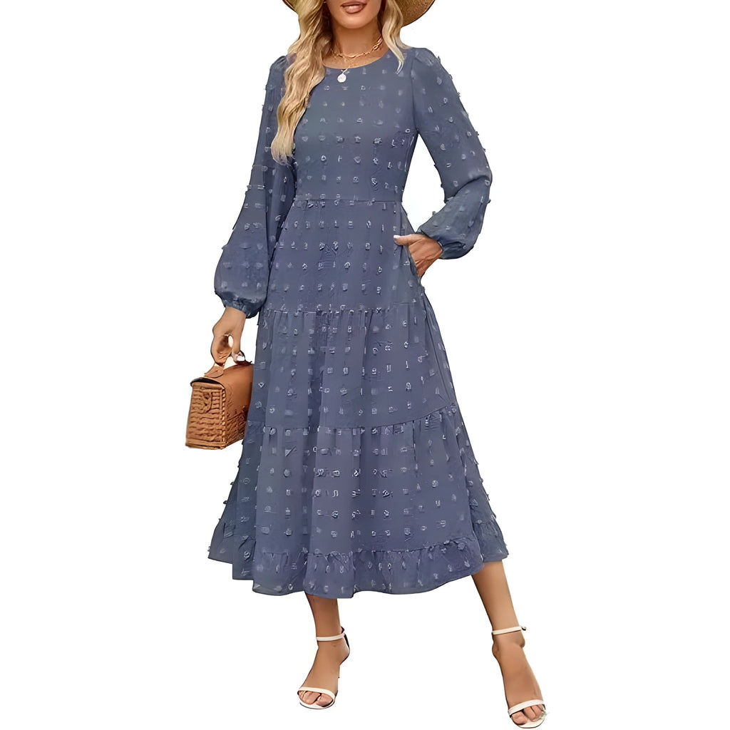 A woman wearing a beige high-waist long sleeve dress with ruffle detailing on the sleeves.
