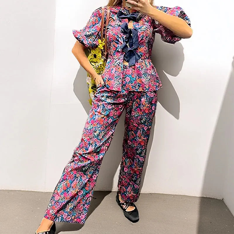 Women's floral print polyester trousers suit with puff sleeve top and matching trousers.