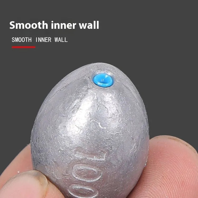 Close-up of a grey olive-shaped lead fishing sinker with scale texture, showing the central hole for rigging.