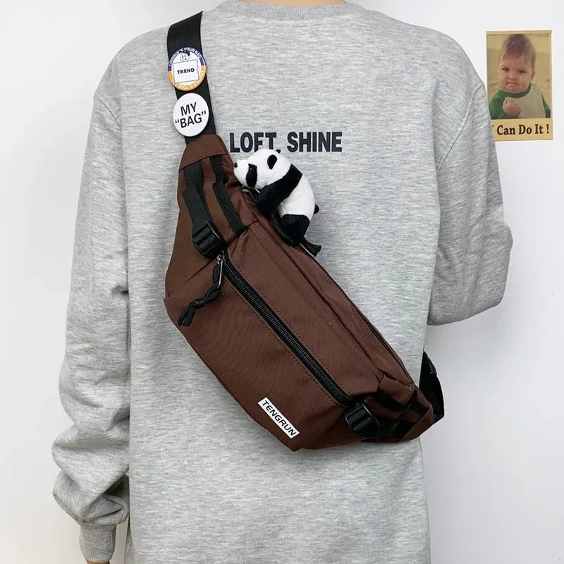 Trendy chest bag for men in Oxford cloth with letter pattern, adjustable strap, and two random badges on a plain background