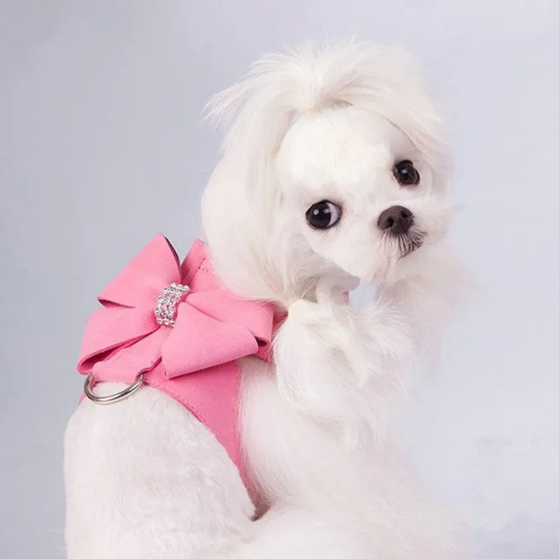 A pink microfiber dog chest strap with a decorative bow, sized for a small puppy.