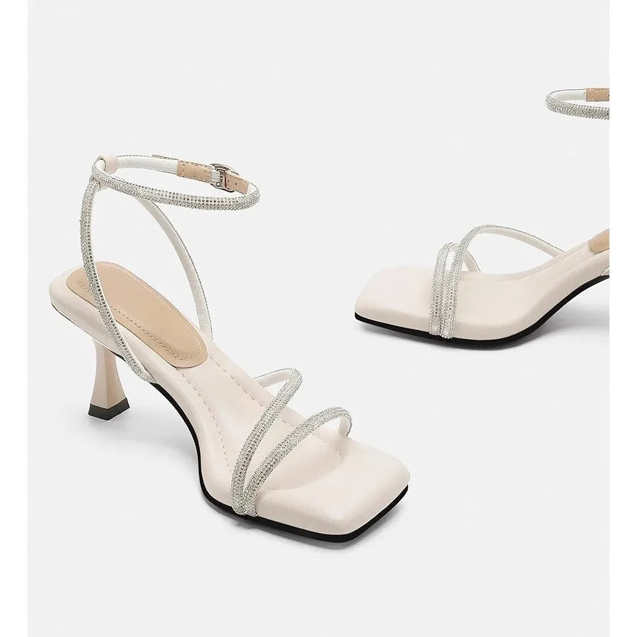 Women's silver rhinestone sandals with square toe and ankle strap buckle on a rubber sole.