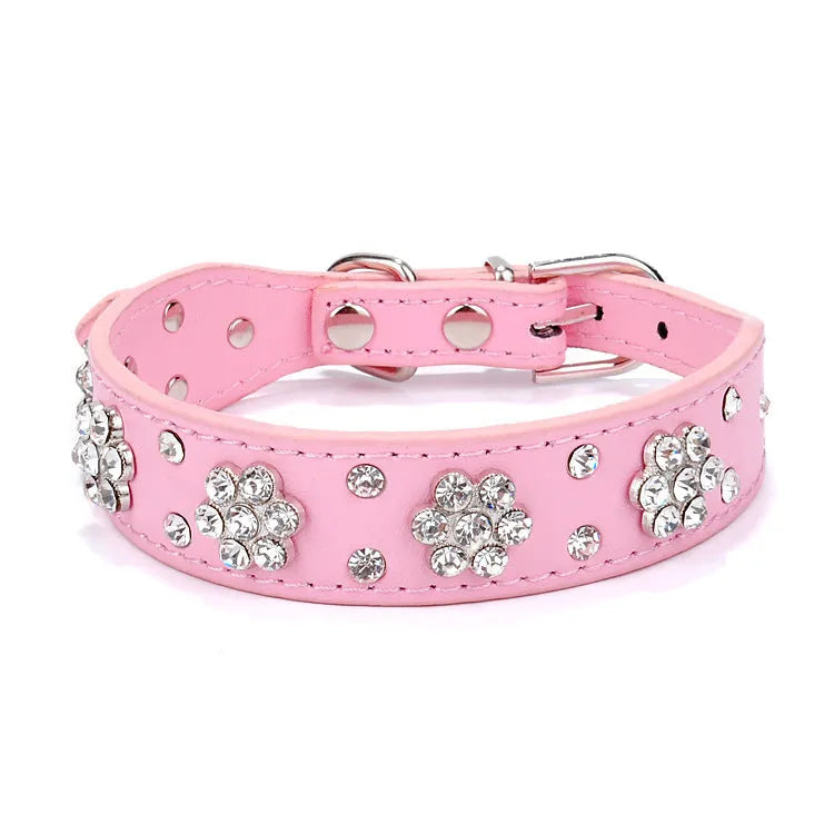 A black PU leather dog collar with a sparkling rhinestone flower pattern and metal studs, showing an adjustable metal buckle.