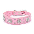 A black PU leather dog collar with a sparkling rhinestone flower pattern and metal studs, showing an adjustable metal buckle.