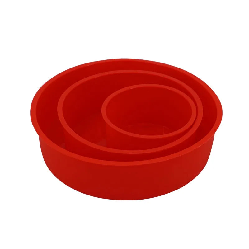 Set of three bright red round silicone cake moulds in 4-inch, 6-inch, and 8-inch sizes on a kitchen counter.