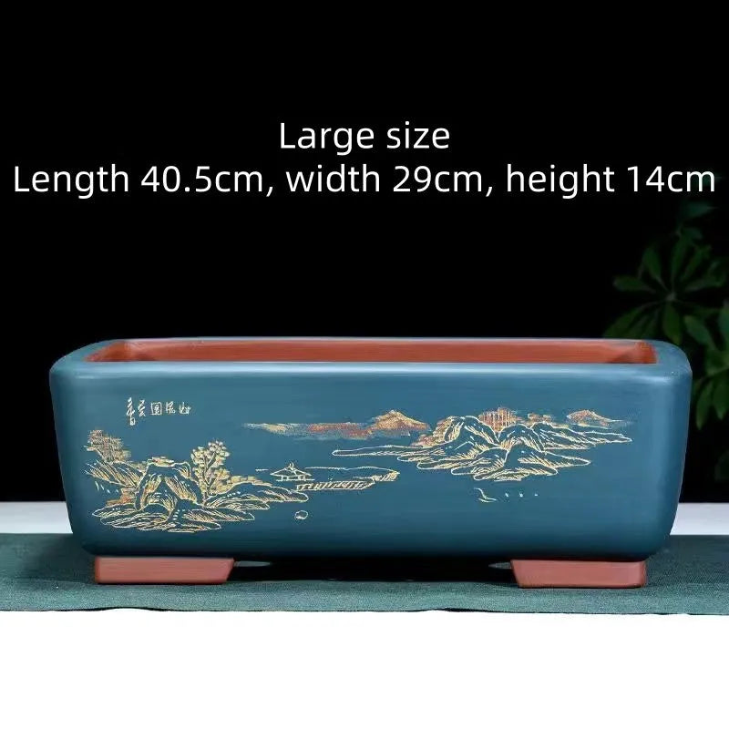 Handmade deep blue black rectangle purple clay bonsai pot on a wooden surface.