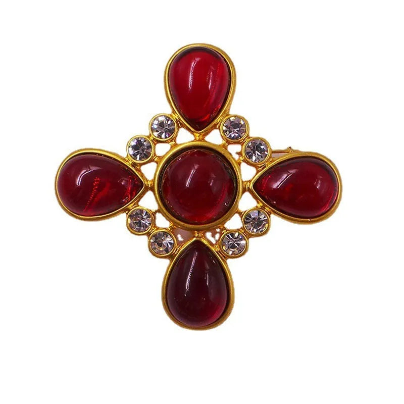 Close-up of a vintage medieval baroque style zinc alloy brooch with a crystal cross centrepiece.