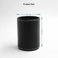 Small round black leather pen holder on a desk.