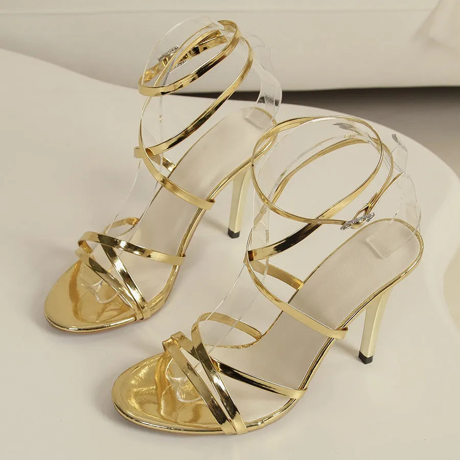 Women's black buckle cross-strap stiletto heel sandals on a white background