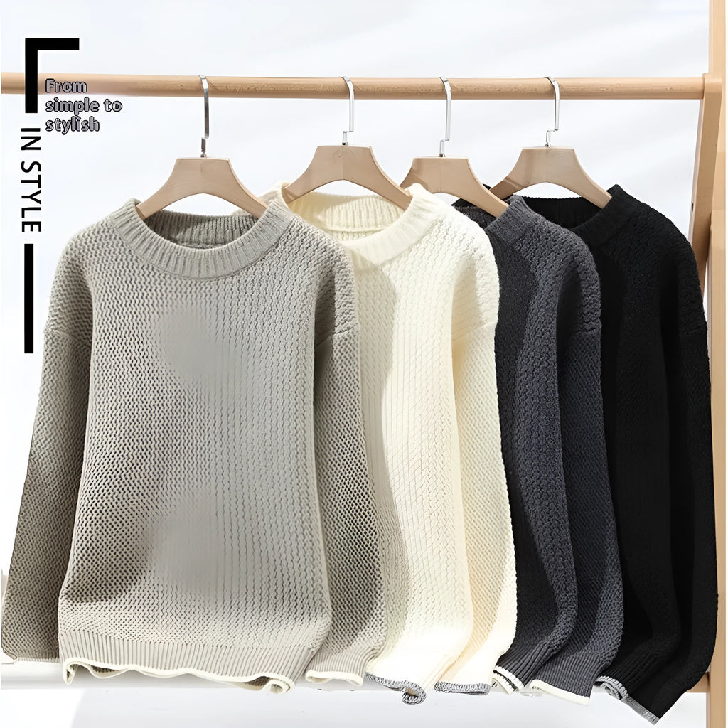 Man wearing a grey loose-fit round neck long sleeve pullover sweater.