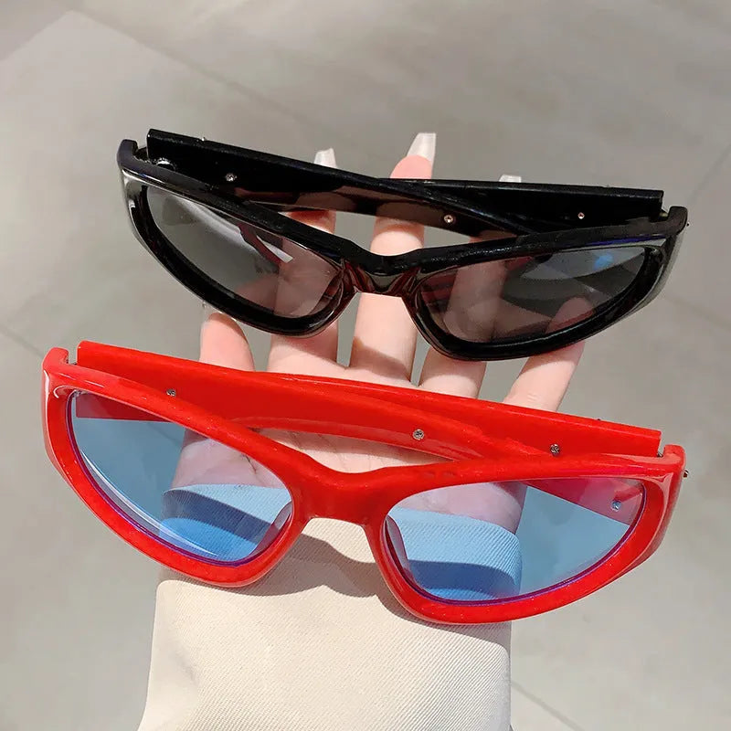 Black frame sports sunglasses with blue polycarbonate lenses on a wooden surface.