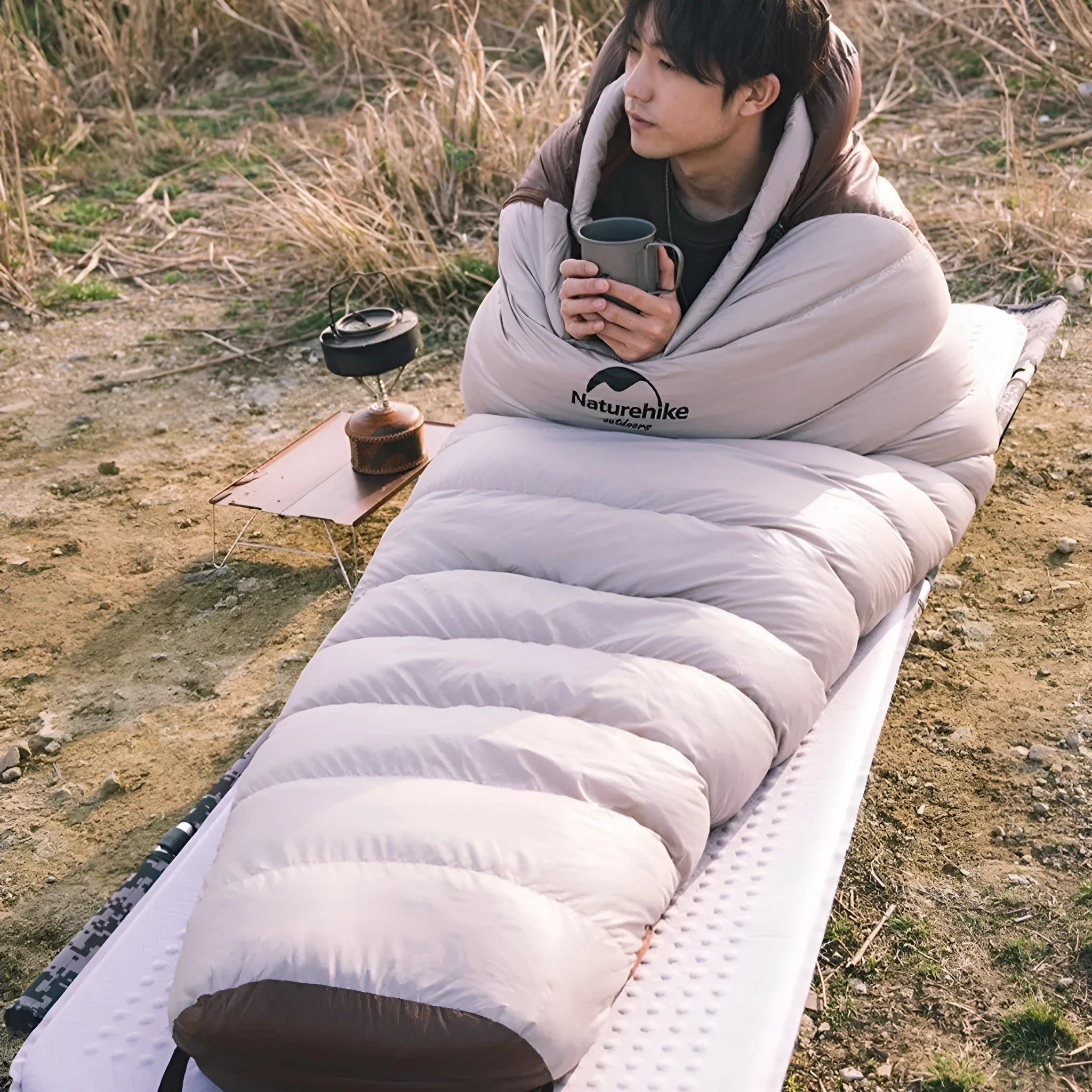 Adult mummy-style sleeping bag with goose down filling shown with its storage bag.